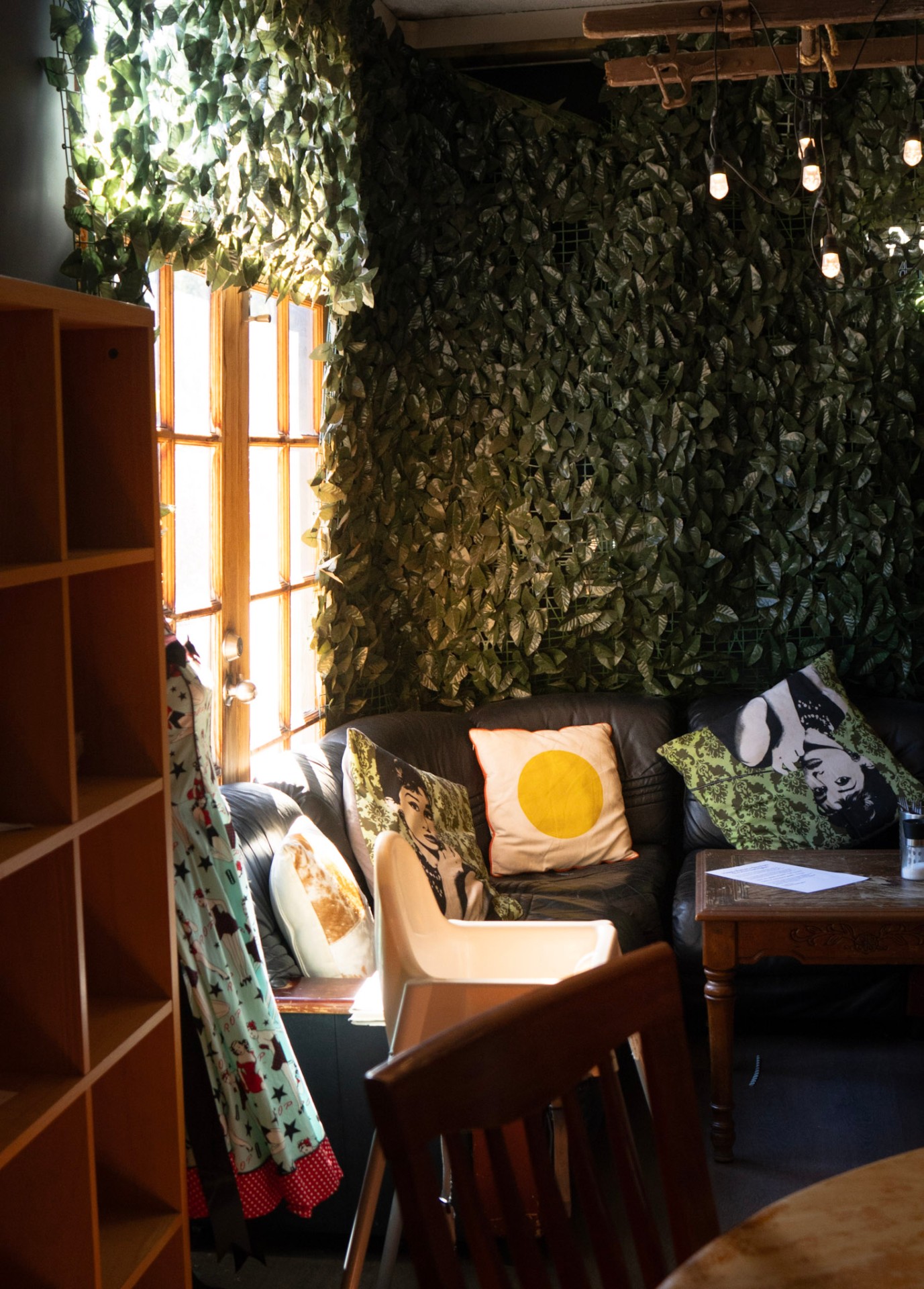 A cozy couch nook tucked behind a living wall of greenery